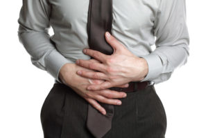 Businessman holding his stomach in pain or indigestion